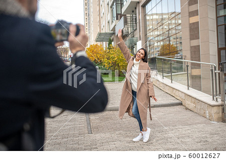 Attractive young woman being photographed by her husband 60012627