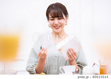 封筒から便箋を取り出す女性 60015014