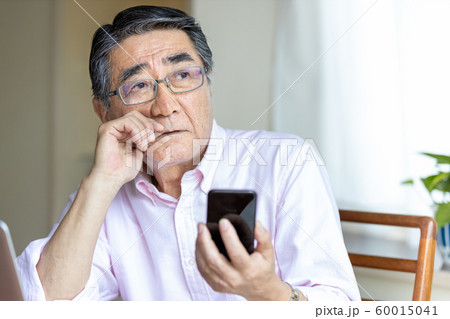 スマホを見るシニア男性　遠くを見る 60015041