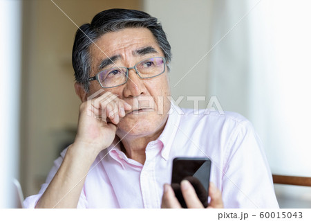 スマホを見るシニア男性　遠くを見る 60015043