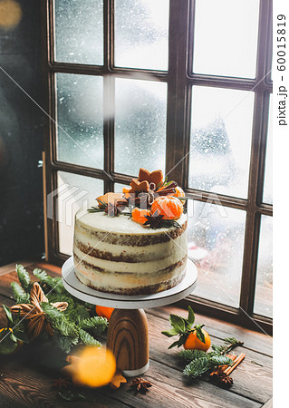 Christmas cake on a window background. Christmas cake stands by the window, which is snowing. Christmas cake on a window background. Christmas cake stands by the window, which is snowing. 60015819