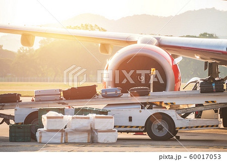 process of carrying luggage bag on a conveyor belt to airplane before departure while traveling at the airport 60017053
