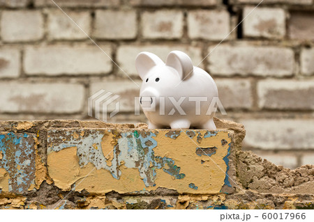 Piggy bank on the wall of dismantled building 60017966