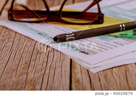1040 tax forms top view with refund check, pencil with glasses 1040 tax forms top view with refund check, pencil with glasses 60020679