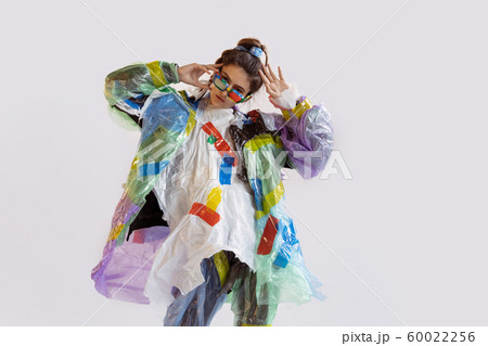 Woman addicted of sales and clothes, wearing plastic, recycling concept Woman addicted of sales and clothes, wearing plastic, recycling concept 60022256