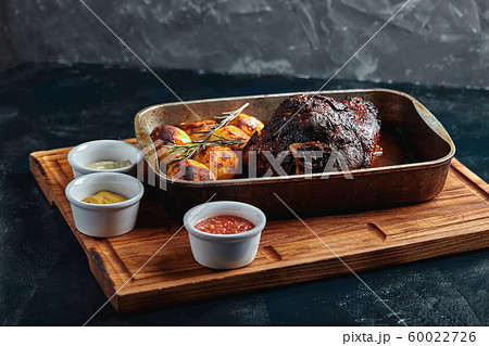 Baked meat and potatoes. A delicious and hearty meal. A large baked piece of meat. Cooked hot food. 60022726