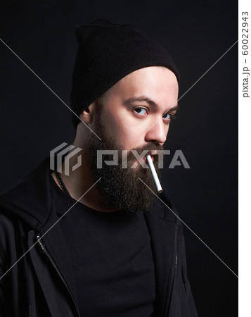 handsome bearded smoking man in Hat 60022943