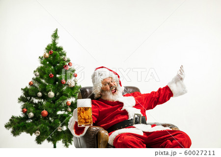 Santa Claus drinking beer near Christmas tree, congratulating of New Year 2020 60027211