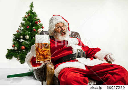 Santa Claus drinking beer near Christmas tree, congratulating of New Year 2020 Santa Claus drinking beer near Christmas tree, congratulating of New Year 2020 60027229