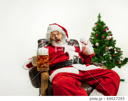 Santa Claus drinking beer near Christmas tree, congratulating of New Year 2020 60027265