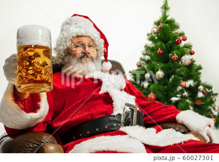 Santa Claus drinking beer near Christmas tree, congratulating of New Year 2020 60027301