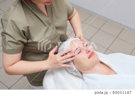 masseuse does face massage to woman in medical clinic masseuse does face massage to woman in medical clinic 60031187