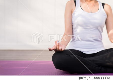 Close up of hand female practices yoga and meditation on the lotus posture Close up of hand female practices yoga and meditation on the lotus posture 60033348