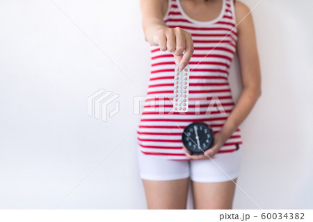 Woman hands holding birth control pill and clock,Concept for contraceptive,Copy space for text on white background 60034382