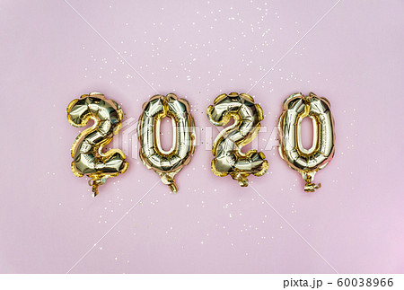 Happy New year 2020 celebration. Gold foil balloons numeral 2020 and golden stars on pastel pink 60038966