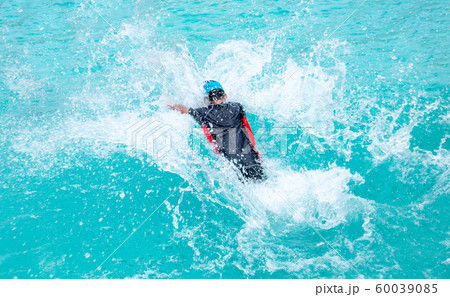 Cute asian boy having fun splashing into pool Cute asian boy having fun splashing into pool 60039085