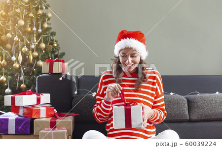 Woman opening Christmas gift 60039224