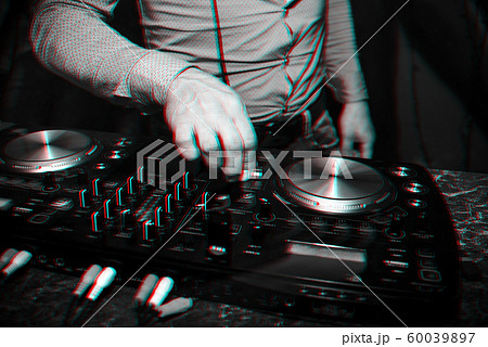 DJ hand controls volume and mix music in professional mixer in nightclub at party 60039897
