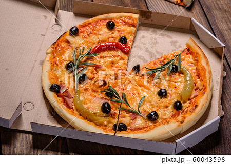 Tasty fresh hot pizza against a dark background Tasty fresh hot pizza against a dark background 60043598