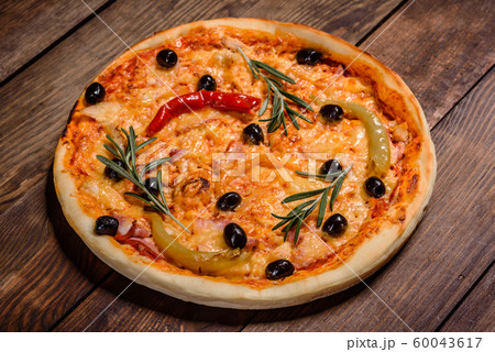 Tasty fresh hot pizza against a dark background Tasty fresh hot pizza against a dark background 60043617