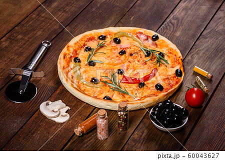 Tasty fresh hot pizza against a dark background Tasty fresh hot pizza against a dark background 60043627