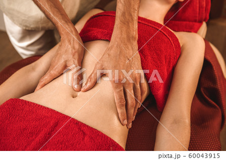 Alternative Medicine. Therapist healing woman doing ayurvedic massage on belly close-up Alternative Medicine. Therapist healing woman doing ayurvedic massage on belly close-up 60043915