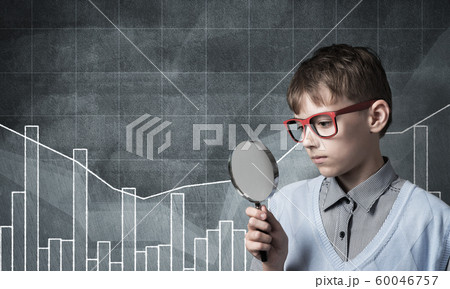 Curious school boy with magnifier 60046757