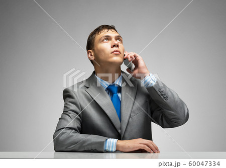 Young man talking on phone and looking upward. Young man talking on phone and looking upward. 60047334