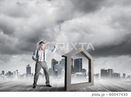 Manager man crashing stone home as symbol for real estate insurance 60047430
