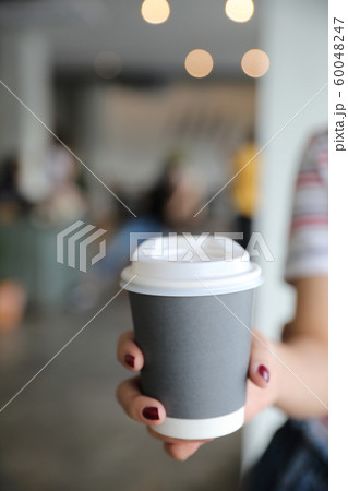 take home hot cappuccino or Latte art coffee made from milk with female hand 60048247