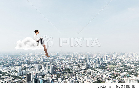 Businesswoman or accountant on cloud floating high above modern city 60048949