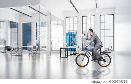 Manager riding bicycle at conference hall 60049331