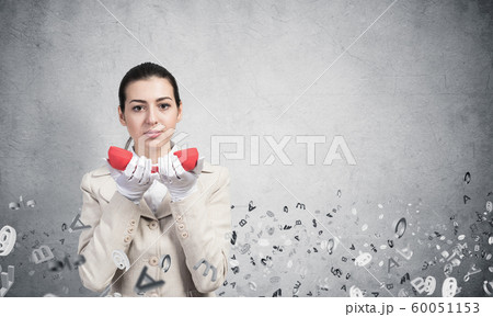 Attractive woman holding vintage red phone 60051153