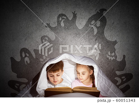 Engrossed little kids reading book in bed 60051343
