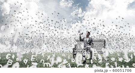 Businessman in summer park announcing something in loudspeaker and symbols fly around Businessman in summer park announcing something in loudspeaker and symbols fly around 60051706