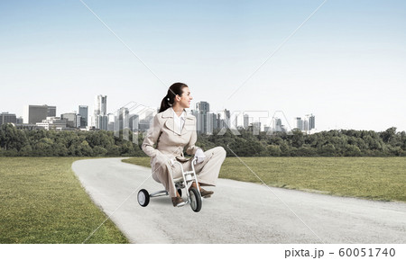 Beautiful young woman riding children's bicycle Beautiful young woman riding children's bicycle 60051740
