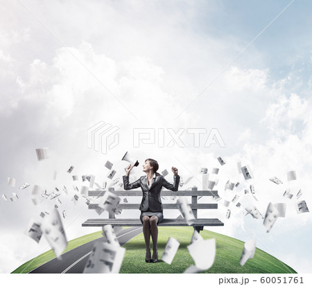 Business woman with megaphone on wooden bench Business woman with megaphone on wooden bench 60051761