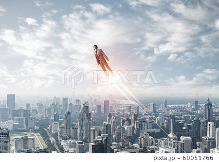 Businessman in suit and aviator hat flying in sky 60051766