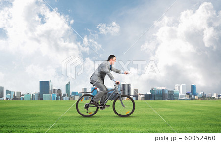 Businessman with paper documents in hand on bike 60052460