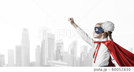 Girl power concept with cute kid guardian against cityscape background Girl power concept with cute kid guardian against cityscape background 60052830