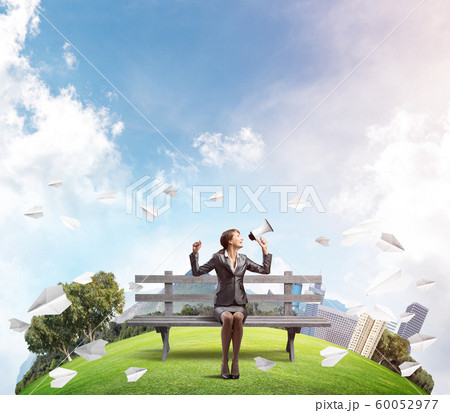 Business woman with megaphone on wooden bench Business woman with megaphone on wooden bench 60052977