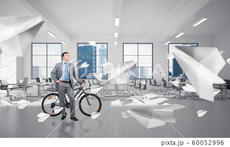 Young man wearing business suit with bike Young man wearing business suit with bike 60052996