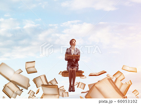 Smiling woman holding open book 60053102