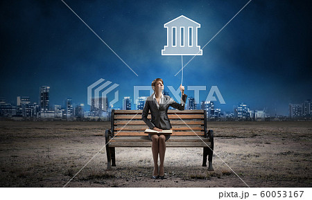 Young woman with open book on wooden bench 60053167