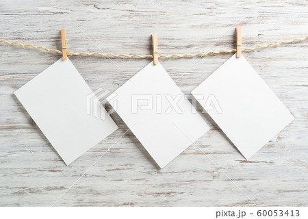 Blank sheets of white paper hanging on twine rope Blank sheets of white paper hanging on twine rope 60053413