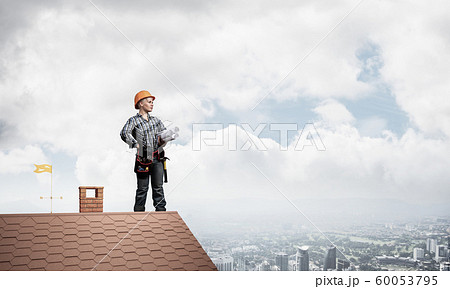Engineer in hardhat with technical blueprints Engineer in hardhat with technical blueprints 60053795