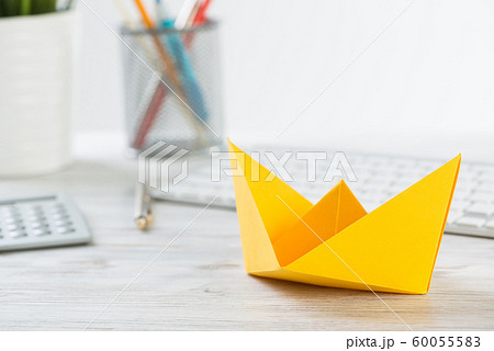 Workspace with office desk and yellow paper ship Workspace with office desk and yellow paper ship 60055583