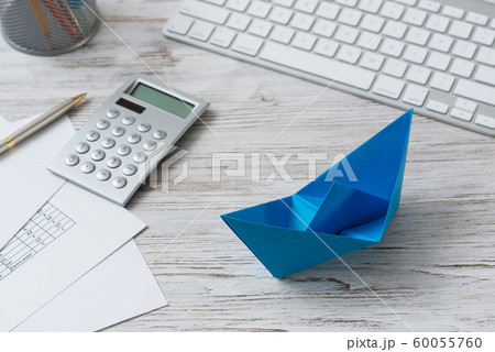 Office workspace with blue paper ship 60055760