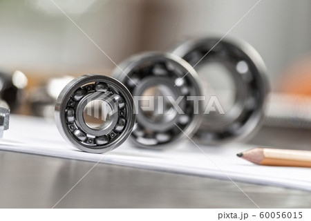 Three various ball bearings lying on paper sheet Three various ball bearings lying on paper sheet 60056015