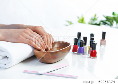 Closeup female hands in wooden bowl with water Closeup female hands in wooden bowl with water 60056374